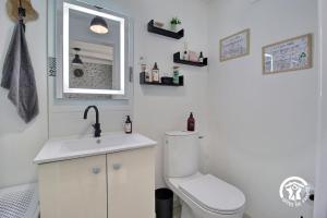 a bathroom with a toilet and a sink and a mirror at Le tigîte b&b in Allaire