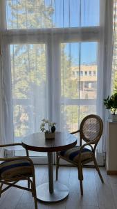 a table and chairs in a room with a window at Black Pearl Jacuzzi Apartament in Sopot +11 photos