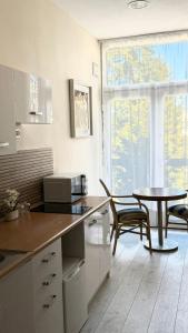a kitchen with a table and a table and a window at Black Pearl Jacuzzi Apartament in Sopot