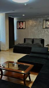 a living room with two beds and a coffee table at Black Pearl Jacuzzi Apartament in Sopot
