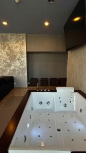 a large white bath tub in a room at Black Pearl Jacuzzi Apartament in Sopot