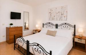 a bedroom with a black and white bed and a television at Casa Rosada Alghero in Alghero