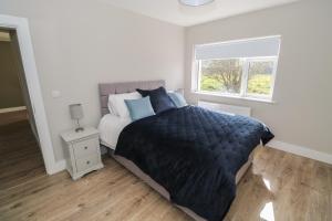 a bedroom with a bed with a black comforter and a window at Red House in Galway