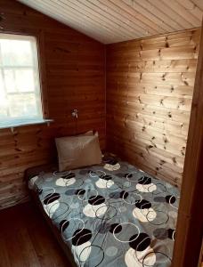 a bedroom with a bed in a wooden cabin at Cabin at the Gate to Österlen in Degeberga