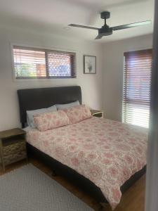 a bedroom with a bed and a ceiling fan at Spacious home with pool in Kippa-Ring in Newport +4 photos