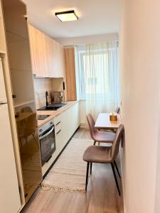 a small kitchen with a table and chairs and a window at Piața Ovidiu 14 Loft in Constanţa