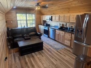 a kitchen with a leather couch and a refrigerator at Small Cabin Over Garage with lake access and small dock in Sevierville +38 photos