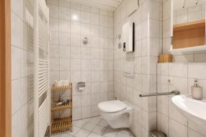 a white bathroom with a toilet and a sink at Superior Apt mit Seeblick K2 002 in Spalt +17 photos