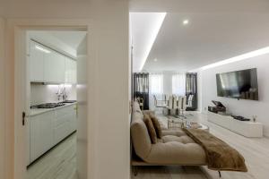 a living room with a couch and a kitchen at Spacious 3-bedroom condo near Lisbon Airport in Lisbon +16 photos