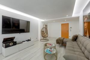 a living room with a couch and a tv at Spacious 3-bedroom condo near Lisbon Airport in Lisbon