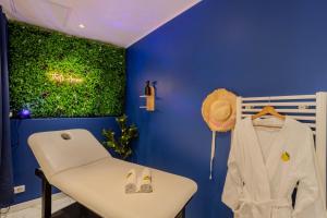 a room with a green wall and a white table at Ciao Bella Wellness Suite - Luxury Jacuzzi, Massage Table & AC in Central Nice in Nice