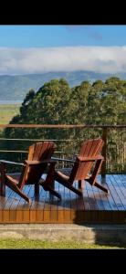 two wooden benches sitting on top of a wooden deck at Oliveira mountain House in Tijucas +32 photos