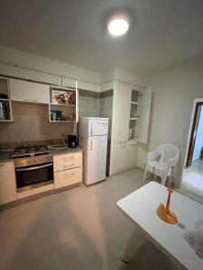 a kitchen with a white refrigerator and a table at HERGLA Sousse Zone Touristique in Harqalah