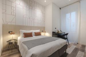 a bedroom with a large bed and a desk and a window at Rooms Boutique Carducci in Trieste