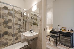 a bathroom with a sink and a shower and a desk at Rooms Boutique Carducci in Trieste +65 photos
