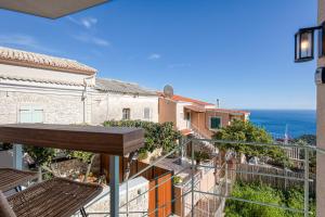 a balcony with a view of the ocean at TINY HOUSE STUDIO AT COURTYARD COTTAGE CORFu in Lákones