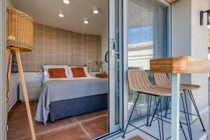 a small bedroom with a bed and a balcony at TINY HOUSE STUDIO AT COURTYARD COTTAGE CORFu in Lákones