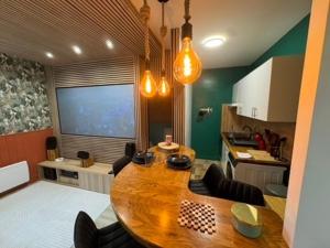a kitchen with a wooden table with chairs and a kitchen at Séjour Château Moderne avec Cinéma in Verberie