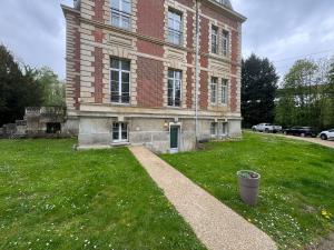 a large brick building with a green lawn in front of it at Séjour Château Moderne avec Cinéma in Verberie