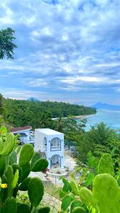 a white building with a view of the ocean at De BOUGENVILLE Tulap Beach Front in Watulanei