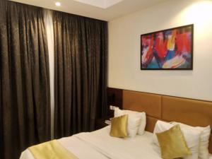 a hotel room with a bed and a painting on the wall at Caritas Inn Igbobi in Lagos
