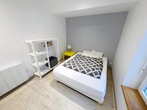 a bedroom with a bed and a book shelf at Le Petit Curie in Gien