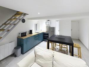 a kitchen with a couch and a table in a room at Le Petit Curie in Gien