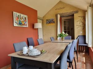 a dining room with a wooden table and blue chairs at Chambres d'Hôtes du Paillé in Thenay +19 photos