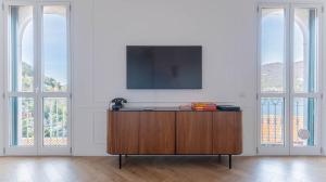 a room with a tv on a wall with windows at LEtoile du Lac in Blevio