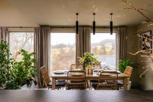 a dining room with a table and chairs and a large window at Larch House in Blairgowrie