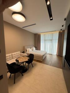 a living room with a bed and a table and chairs at Sea Breeze Lighthouse in Nardaran