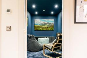 a door into a room with a chair and a painting at Larch House in Blairgowrie
