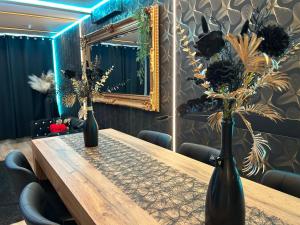 a wooden table with two vases on it with a mirror at Chambre business-romantique, jacuzzi, billard, clim in Verviers