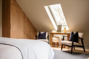 a bedroom with a bed and a desk and a window at Larch House in Blairgowrie