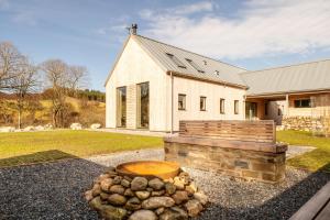 a house with a building with a pile of logs at Larch House in Blairgowrie