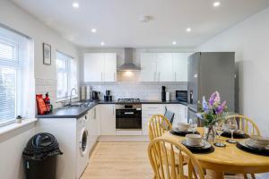 a kitchen with a wooden table and a dining room at Spacious 3 Bedroom House in Ashton-under-Lyne by Eason Stays with Free Parking and Courtyard View in Stalybridge