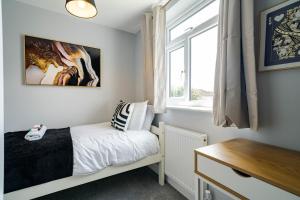 a small bedroom with a bed and a window at Spacious 3 Bedroom House in Ashton-under-Lyne by Eason Stays with Free Parking and Courtyard View in Stalybridge