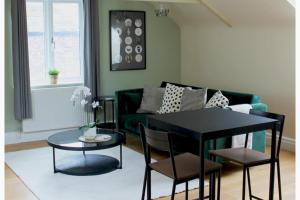 a living room with a black table and a green couch at 1 Bed Loft - Sleeps 2 - Parking - Wifi in Newport +5 photos