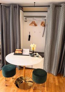 a table and two green chairs in a room at Cute, Quiet and Central - Self Check In in Bad Ischl