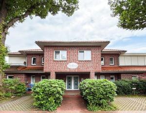 a brick house with bushes in front of it at "Villa Lorenzo" in Bad Zwischenahn