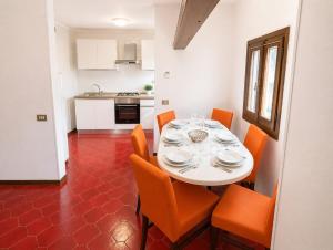 a dining room with a white table and orange chairs at La Casa del Mare in Caorle