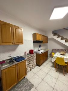 a kitchen with wooden cabinets and a table in it at Il Vicoletto in Biccari