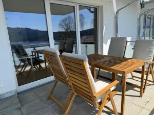 a wooden table and chairs sitting on a balcony at Lakeview Residence in Schluchsee