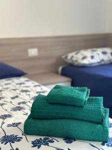 a stack of green towels sitting on top of a bed at Bibione Beach Home in Bibione