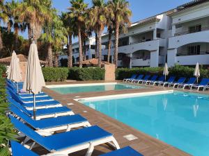 a swimming pool with lounge chairs and a hotel at T2 les pieds dans l eau avec piscine in San-Nicolao