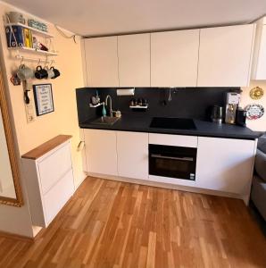 a kitchen with white cabinets and a black counter top at Cute, Quiet and Central - Self Check In in Bad Ischl