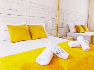 two beds with white and yellow pillows and socks at Refúgio Brisa Mar in Vila do Conde