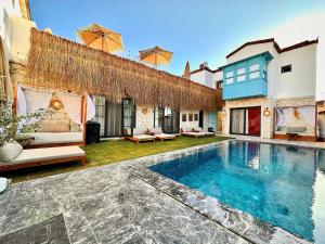 a villa with a swimming pool in a yard at Paradise Hotel Alaçatı in Ildır