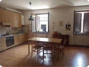 a kitchen with a wooden table and chairs and a table and chairsktop at Casa Lu' in Bosisio Parini