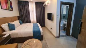 a hotel room with a bed and a bathroom at Caritas Inn Igbobi in Lagos